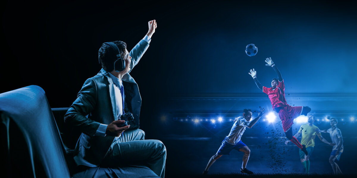 A man playing football (soccer) video game on controller, cheering