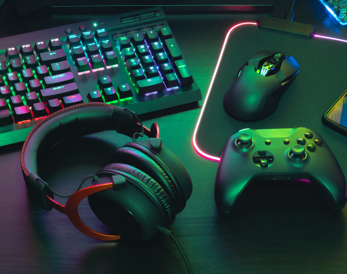 video game player's desk with keyboard, mouse, headphones and controller