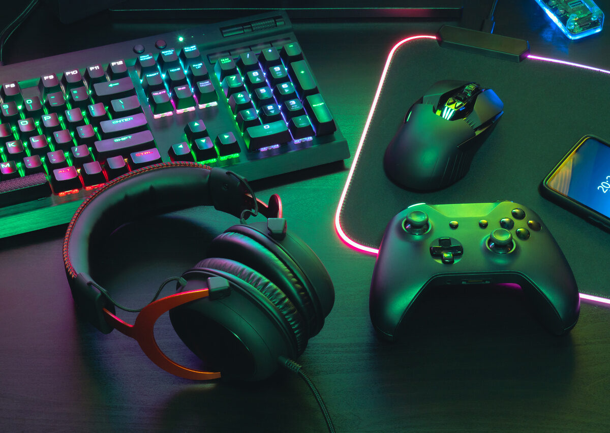 video game player's desk with keyboard, mouse, headphones and controller