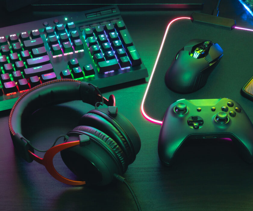 video game player's desk with keyboard, mouse, headphones and controller