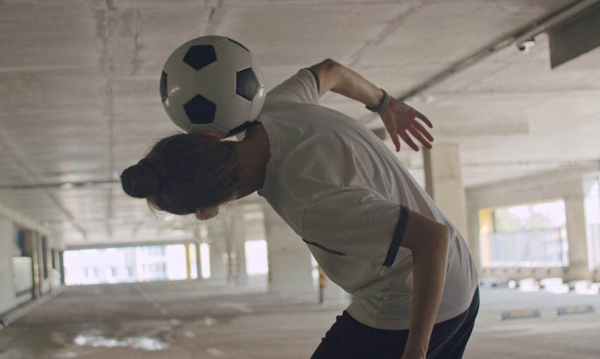 Teenage girl practicing soccer ball tricks