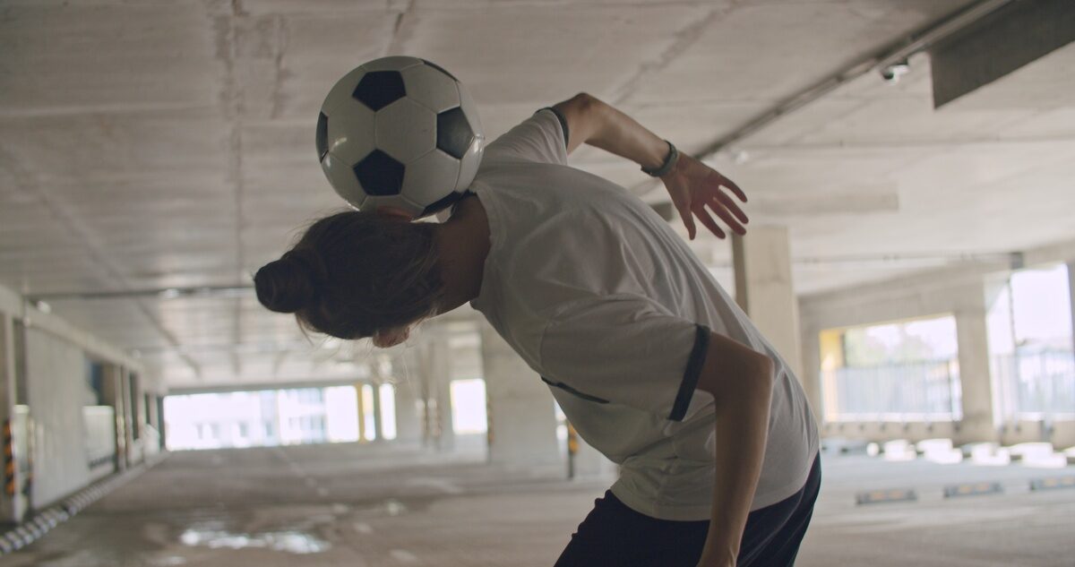 Teenage girl practicing soccer ball tricks