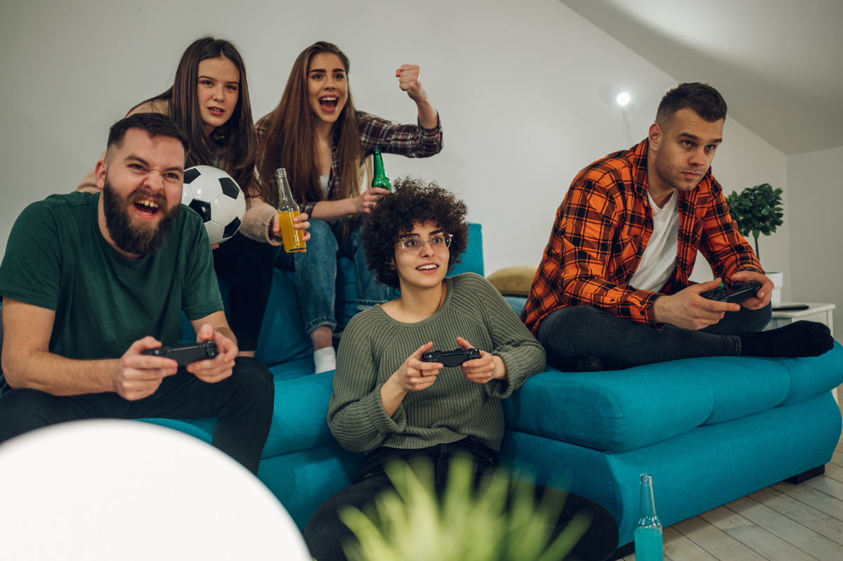 Group of friends with a soccer ball playing video games