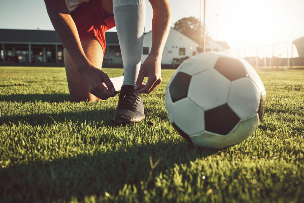 soccer player tying boots to start a practice match