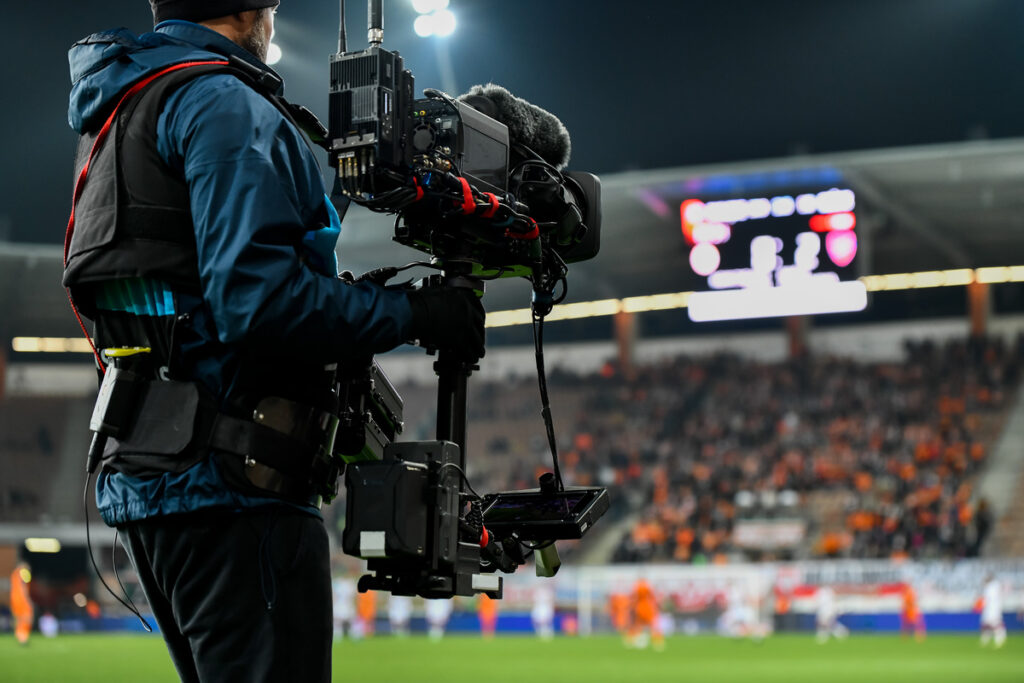 Cameraman recording field during soccer match