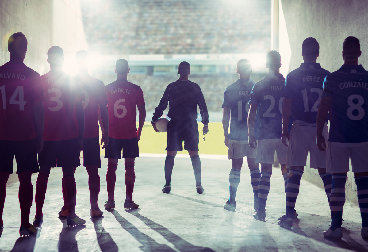 Silhouettes of two football teams entering the field