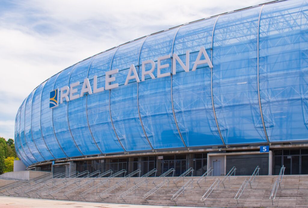 Exterior view of Reale Arena, home of Real Sociedad, featuring its modern blue glass facade.