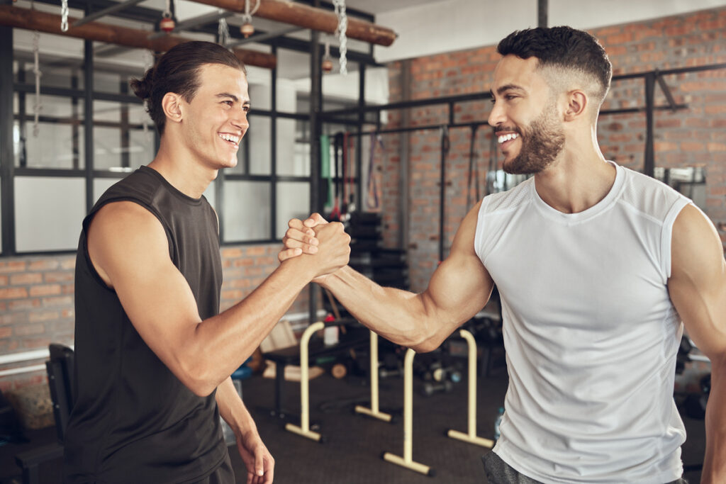 muscular friends shaking hands at gym