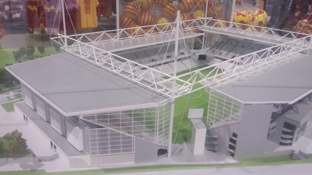 A detailed model showing the stadium's architecture, including the stands, roof structures, and pitch.