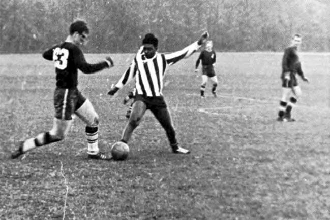 black and white photo of men playing soccer