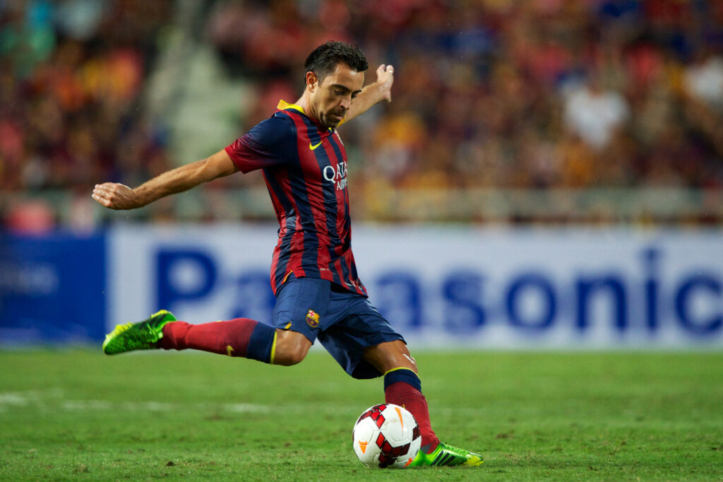 Xavi Hernandez striking a ball during a football game