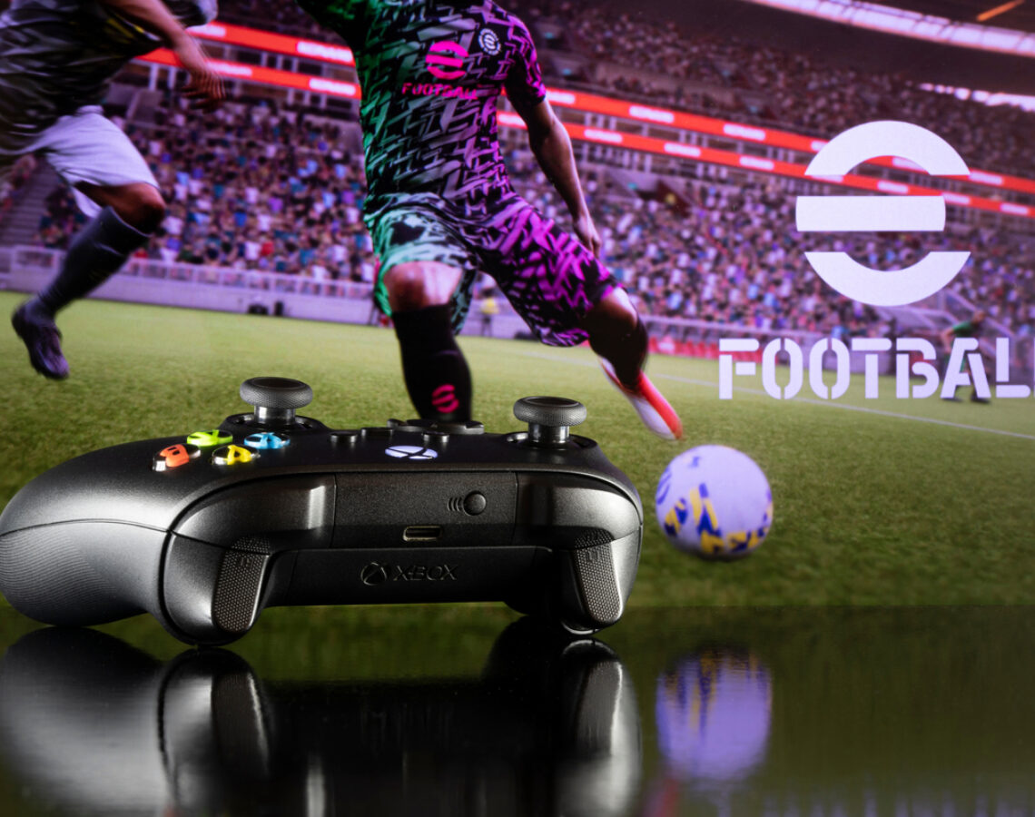 Xbox controller with efootball in background