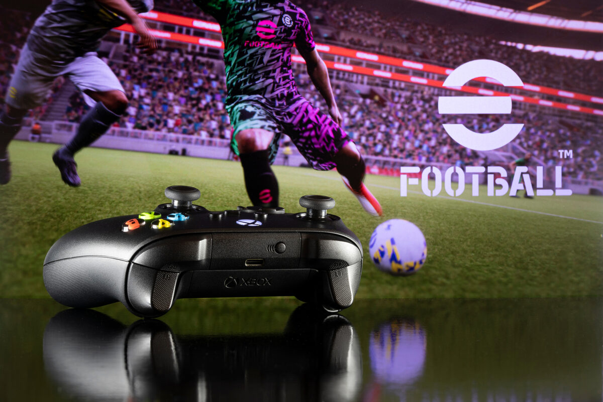 Xbox controller with efootball in background