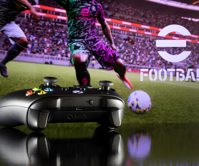 Xbox controller with efootball in background