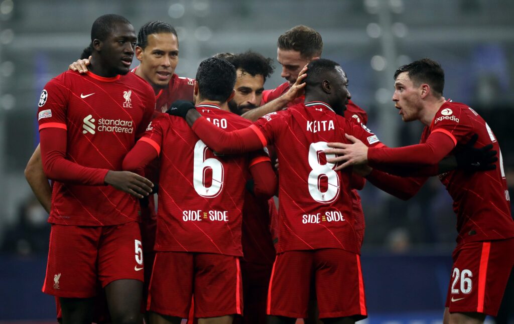 Jogadores do Liverpool comemoram juntos no campo após um momento importante durante a partida.