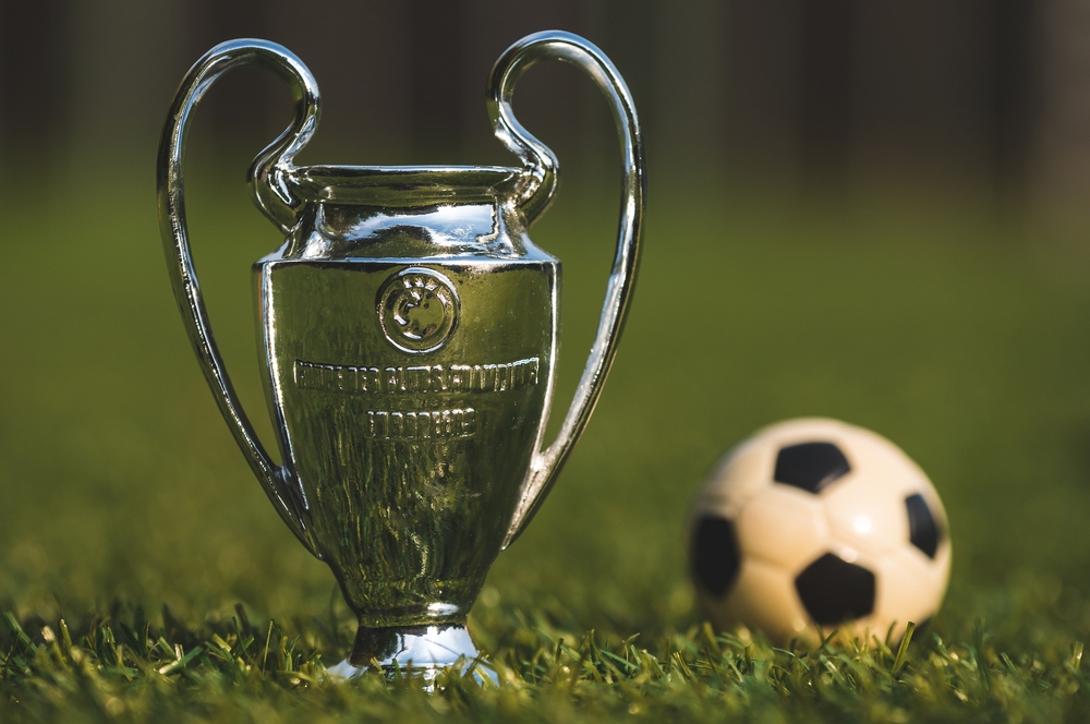 The UEFA Champions League Cup on the green turf of the stadium