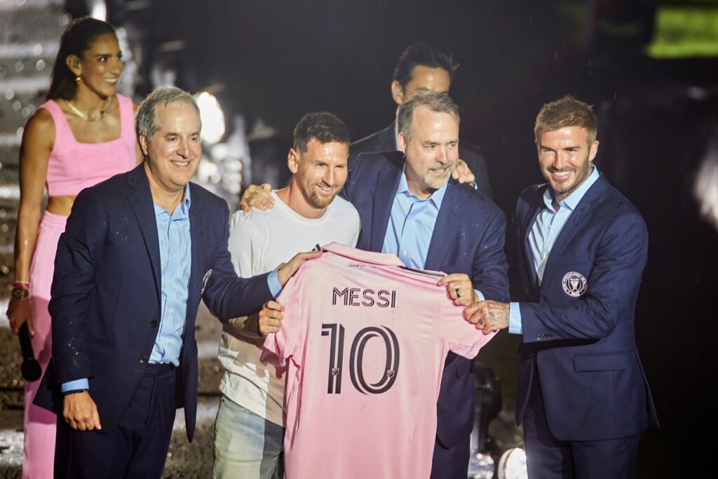 World Cup Champion Leo Messi holding up his shirt, smiling