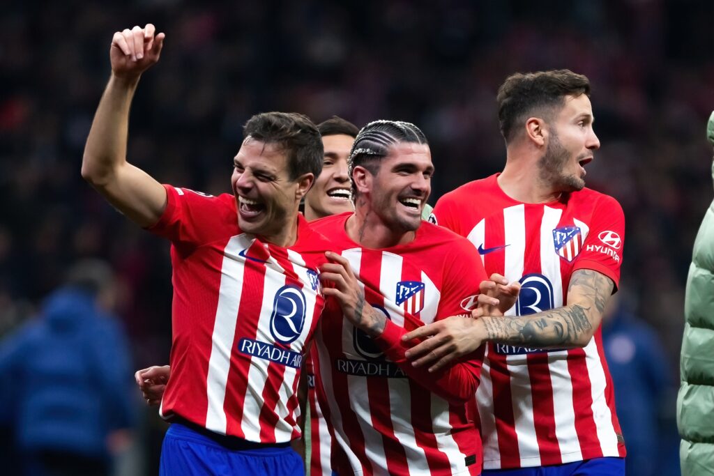 Jogadores do Atlético de Madrid comemoram no campo, sorrindo e vibrando após um momento significativo durante a partida.