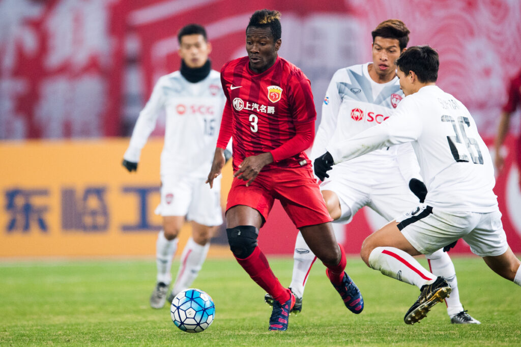 Asamoah Gyan leading the ball during Champions League match