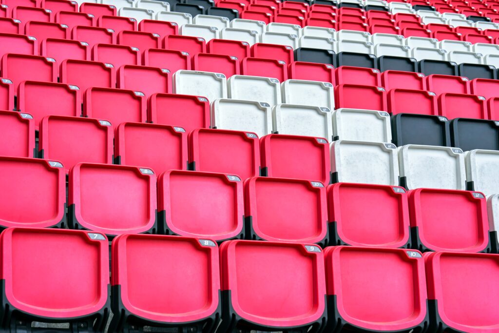 Close-up of stadium seating arranged in a red, white, and black pattern, creating a bold visual contrast.