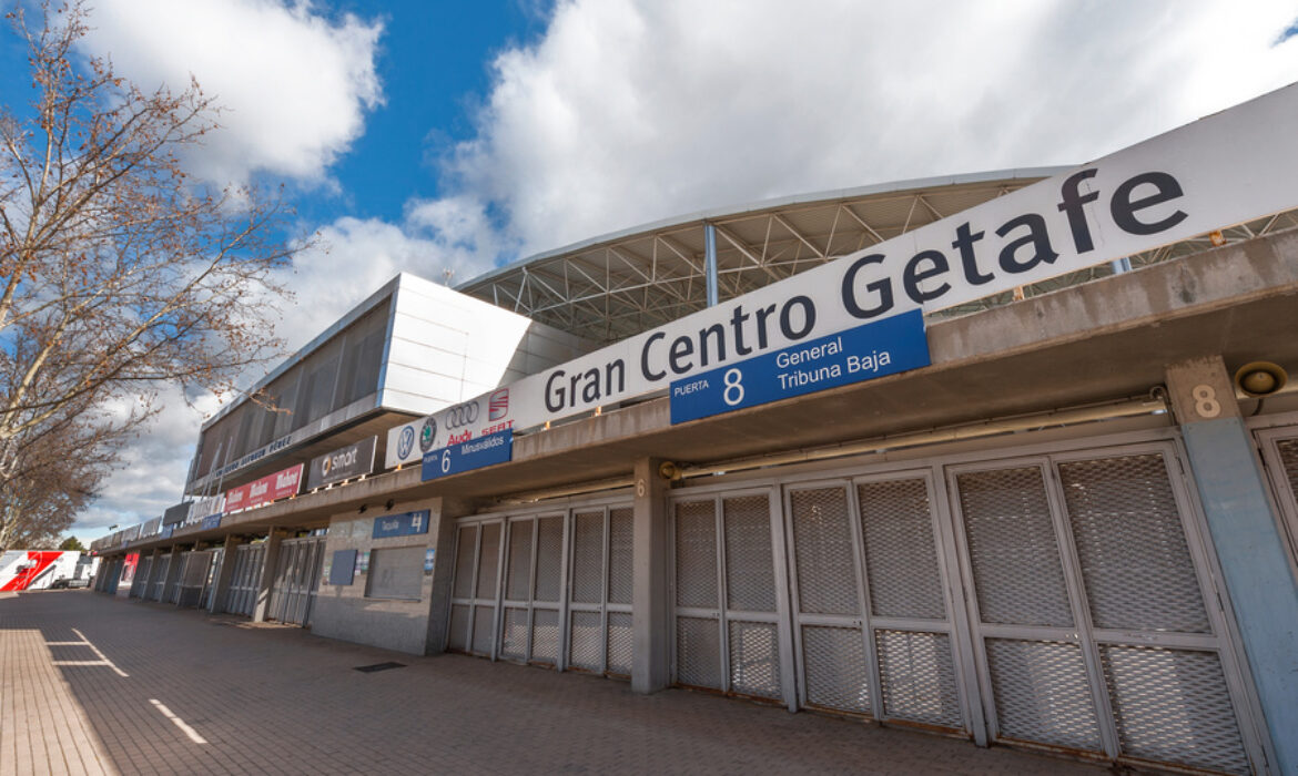 Exterior view of Coliseum Alfonso Pérez stadium in Getafe, Spain, featuring entrance gates with signage reading "Gran Centro Getafe" under a partly cloudy sky.