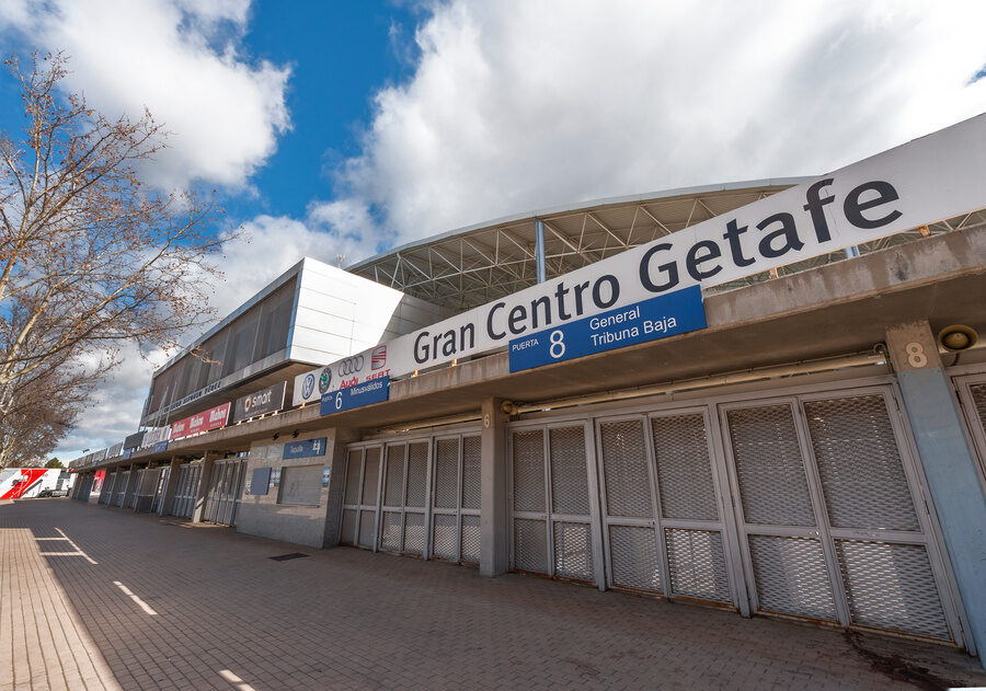 Exterior view of Coliseum Alfonso Pérez stadium in Getafe, Spain, featuring entrance gates with signage reading "Gran Centro Getafe" under a partly cloudy sky.