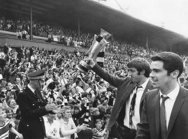 management team members raising a trophy in the Fairs Cup