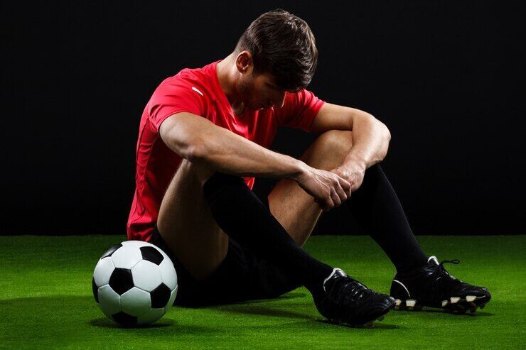 football player sitting on the ground
