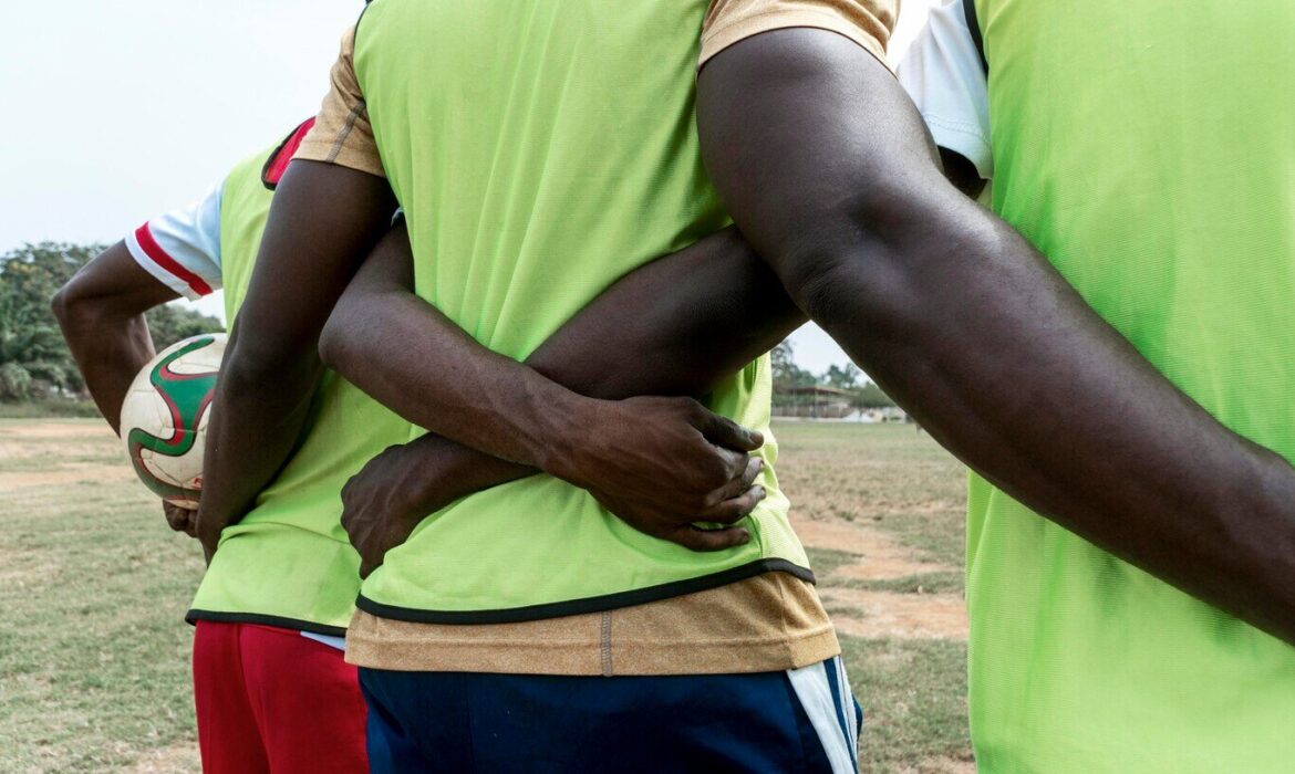 multiple football players hugging each other