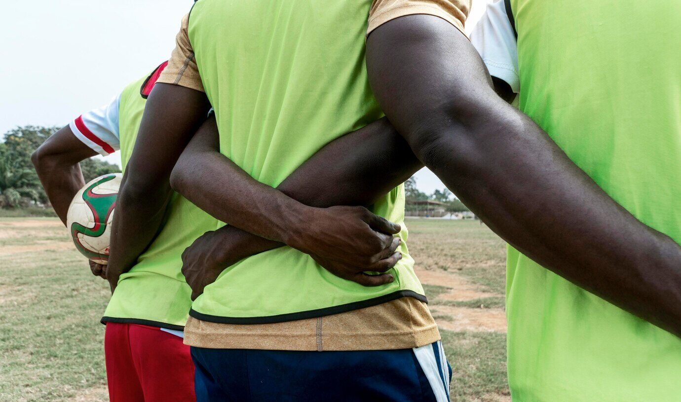 multiple football players hugging each other