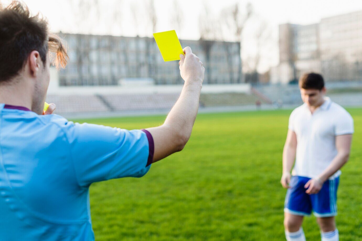 referee giving a football player a yellow card